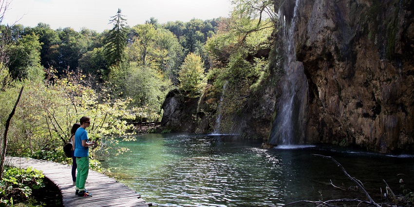 A scenic view of waterfalls and lush greenery at Plitvice Lakes National Park in Croatia.