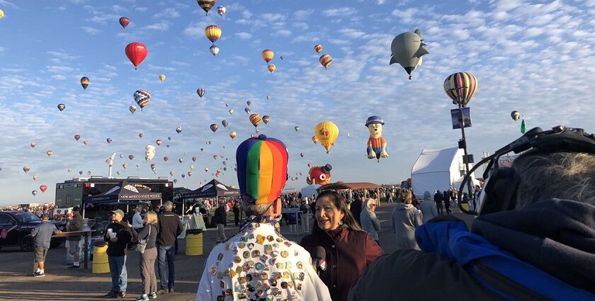 An image of a vibrant scene at the Albuquerque Balloon Fiesta with colourful hot air balloons soaring