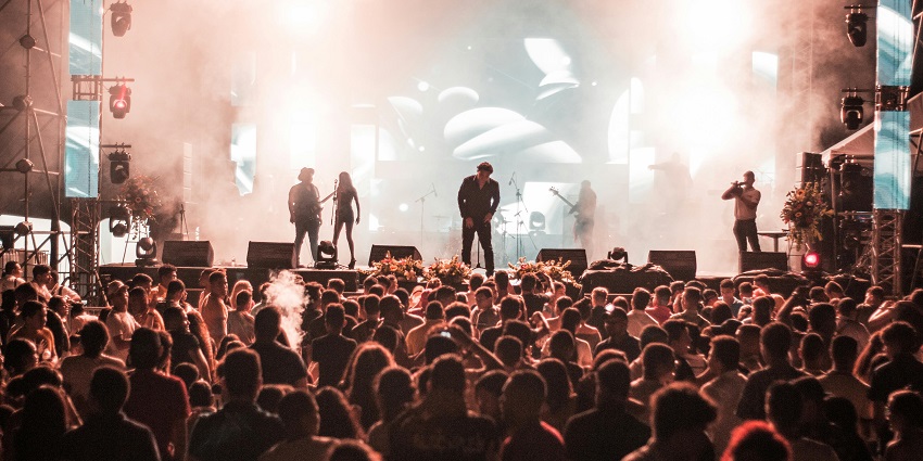 A crowd of people enjoying one of the summer Quebec Music Festivals outdoors.
