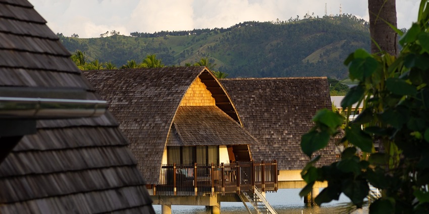 Overwater bungalow at a Fiji resort, surrounded by clear blue sea and sky