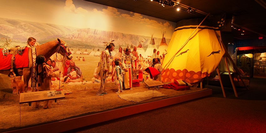 An image of a First Nations doll on display at the Royal Ontario Museum, showcasing traditional attire.