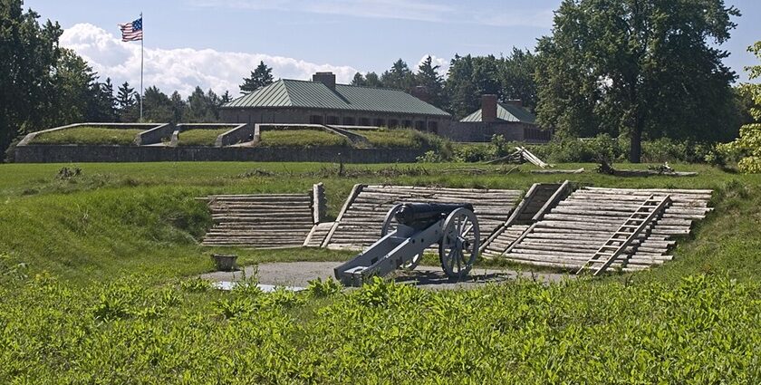 A historical view of the cannon at Old Fort Erie, set on green grass with trees and cloudy skies.