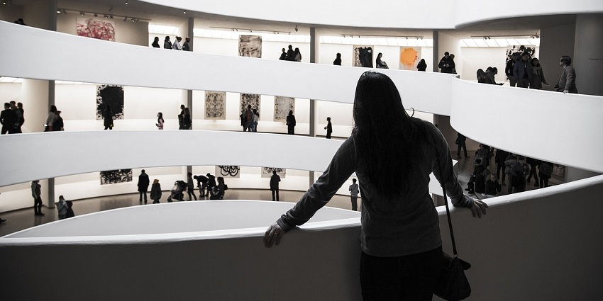 Interior of a modern art museum with abstract sculptures and natural light shadows.