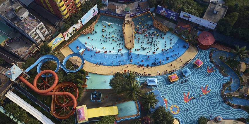 Bird eye view of a water par with a big pool and colourful water slides for everyone