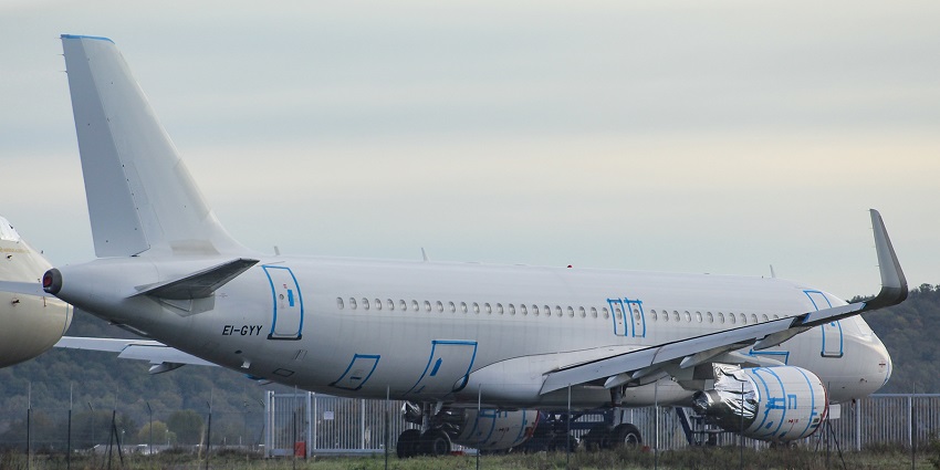 A view of an aeroplane with registration EI-GYY on the runway at an airport.