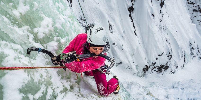 A person ice-climbing with proper gear the Rjukan in telemark surrounded by snow
