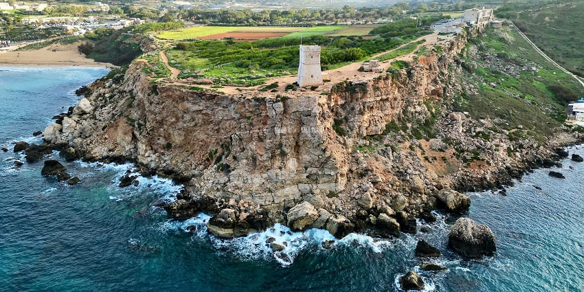 An aerial view of a moderate crowd enjoying at Golden Bay Beach in Malta in the day.