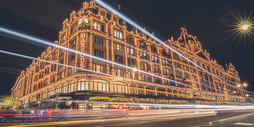 An Image of the brightly lit Harrods, a luxury shopping destination in London.