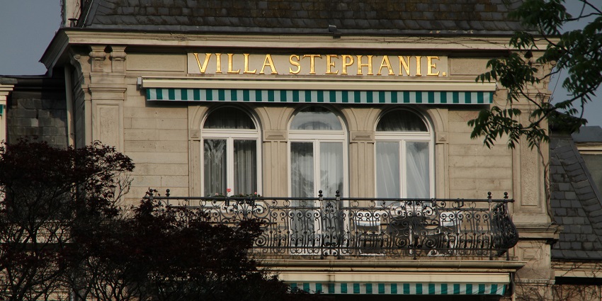 Villa Stephanie written on the hotel building with a balcony, windows, door and trees, a spot for Valentine's Day in Germany.