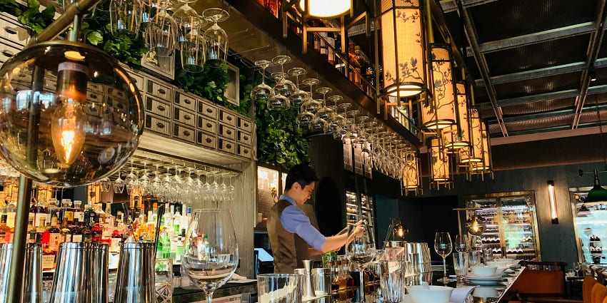 An image of an elegant bartender preparing a finely crafted cocktail in the Hemingway Bar