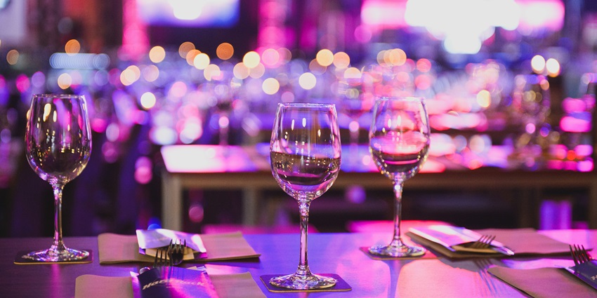 Image of clear wine glasses placed on a table with a fork, and knife on the side