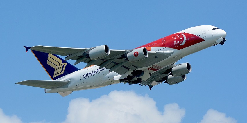 A Singapore Airlines plane with its flag painted on it flies one of the ways to reach Singapore.