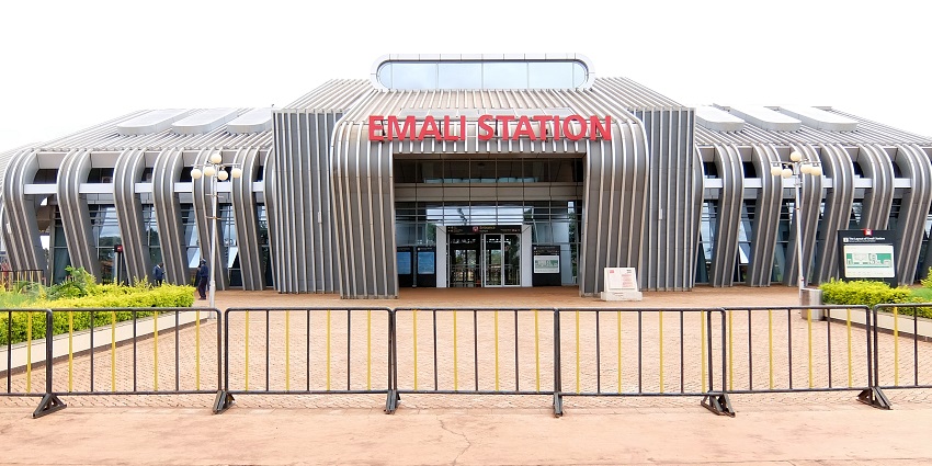 Outside Emali station with its designed building and station name written on it in red.