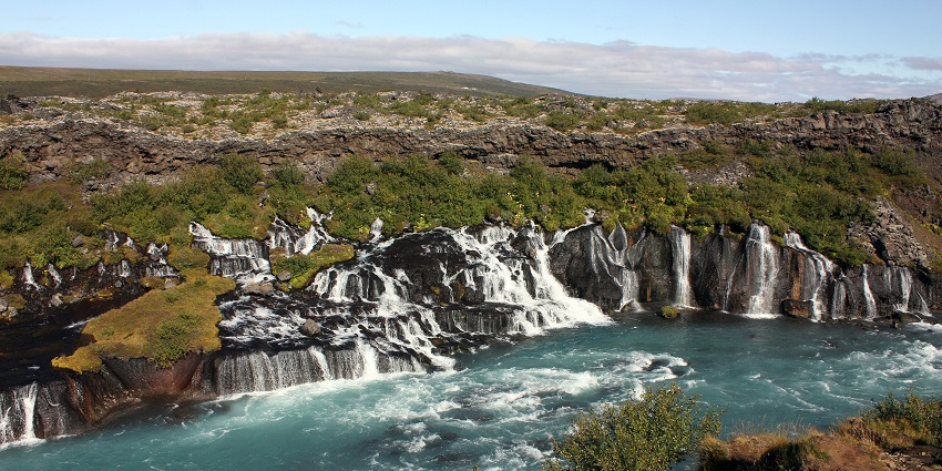 An image of the Hraunfossar Waterfall, a must-see waterfall, among the Iceland waterfalls.