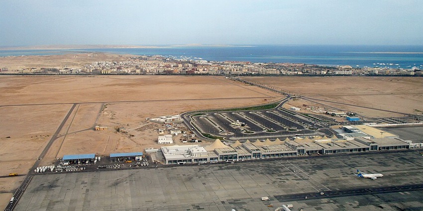 A top view of the Hurghada airport showing the runway, flights, buildings and sea in backdrop