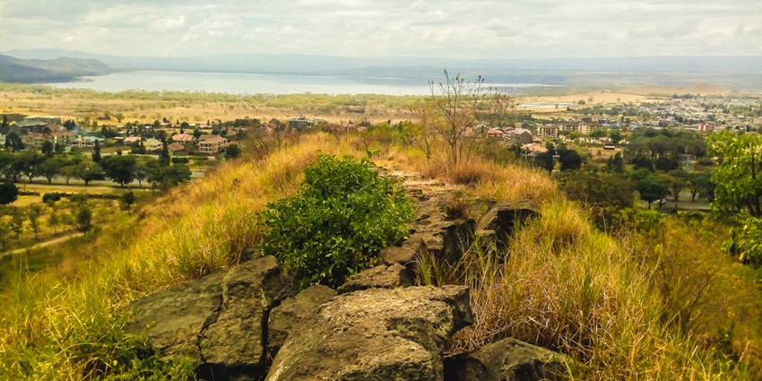 Hyrax Hill with rocky path and a populated town with buildings and a lake visible below