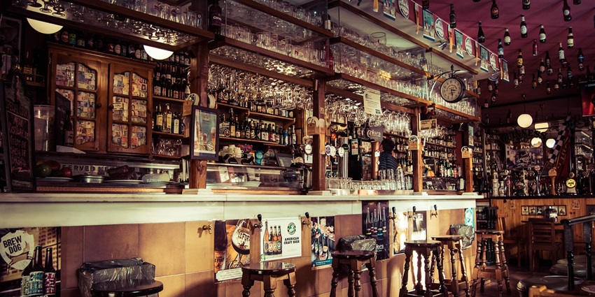 Various alcoholic drinks on a bar counter, including wine and cocktail glasses