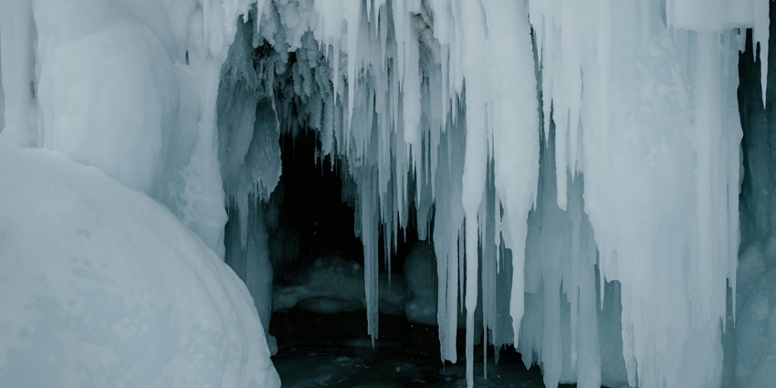 An image of the Kitzsteinhorn Ice Cave, surrounded by snow-covered mountains and glaciers.