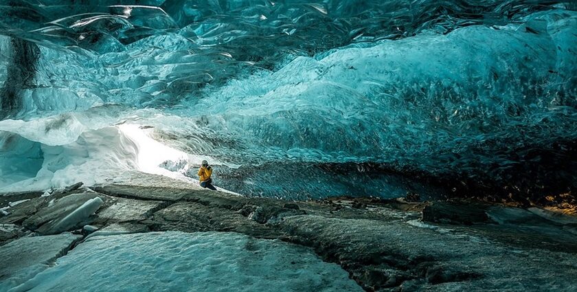 An image of Ice formations inside a cave with sparkling frozen stalactites and blue ice walls.