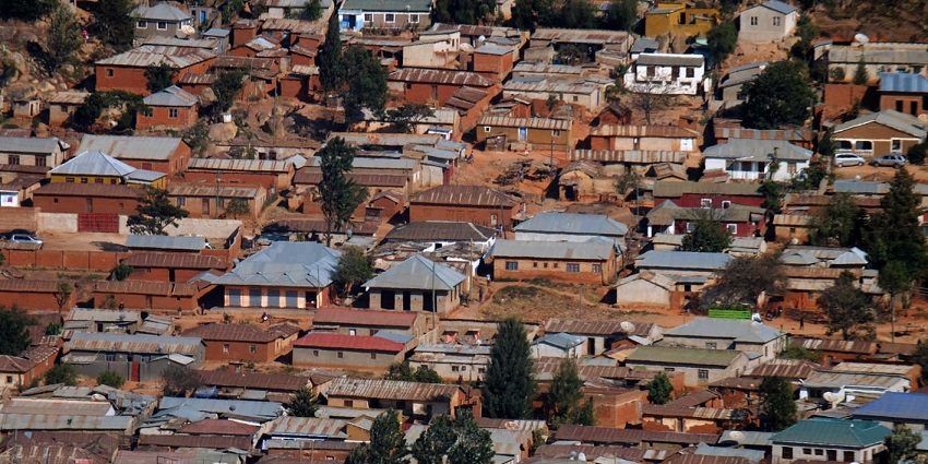 Iringa town from above, with lots of buildings with iron roofing and multiple vehicles