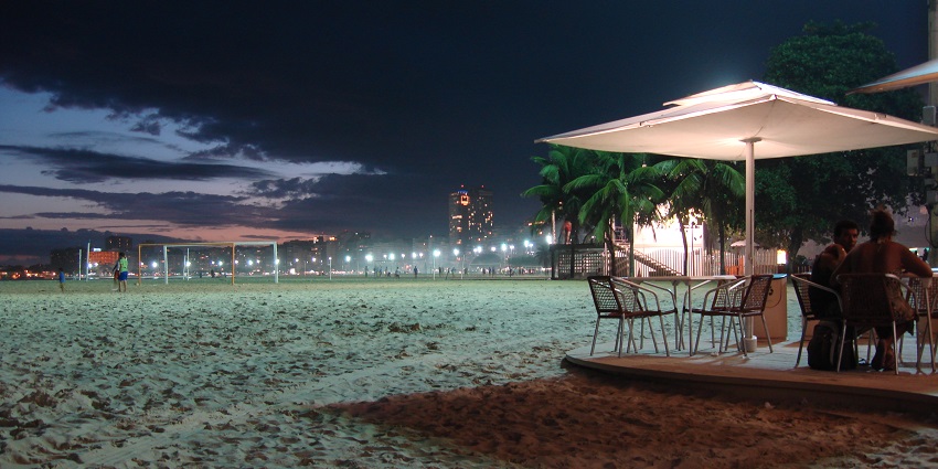 Beach view at night with pristine sands and turquoise waters.