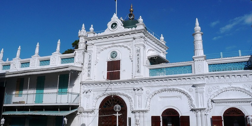 The entrance to the jummah mosque with detailed architecture and a clock on the wall.