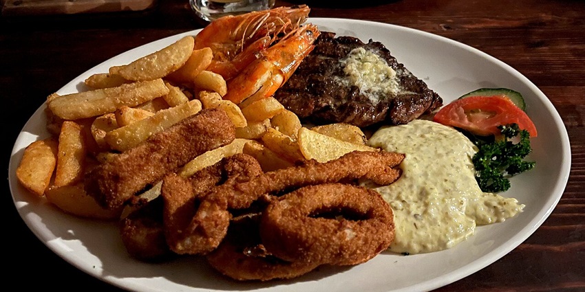 Seafood platter served with fried calamari, prawns and frits with sauce, displaying Dar es salaam nightlife.