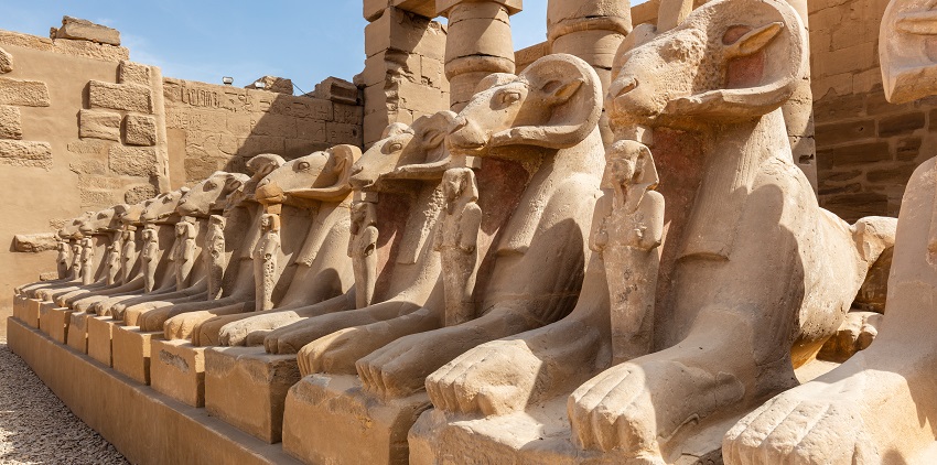 Entrance to the Karnak temple with ruined statues and traditional ruined architecture