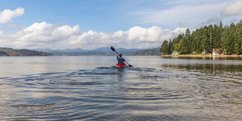 An image of a woman kayaking in Keji Seaside, a popular place for kayaking in Canada.