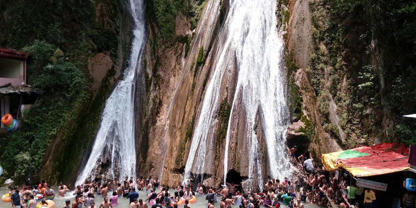 Stunning waterfall surrounded by hills, offering scenic views and relaxation.