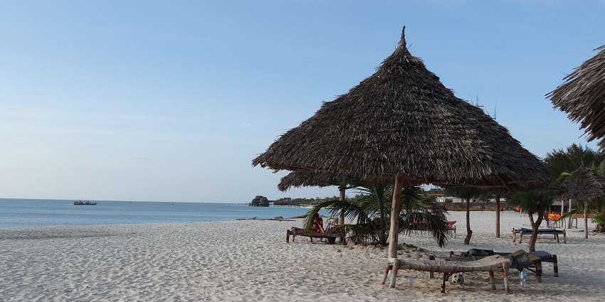 A view of Kendwa Beach, which has shacks and a few seaside chairs along with people.
