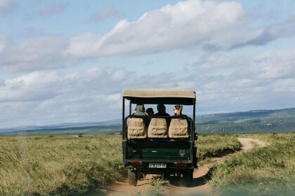 Multiple people on Kenya jungle safari ride surrounded by greenery under the cloudy sky