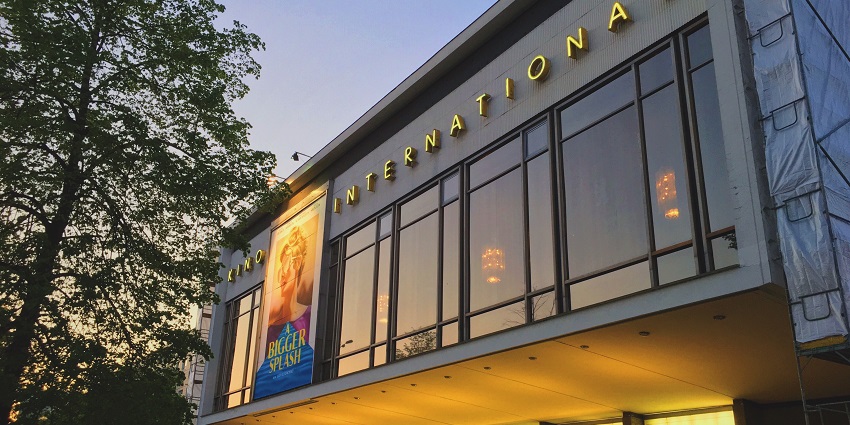 Kino International building lit with small and big movie posters and screening times