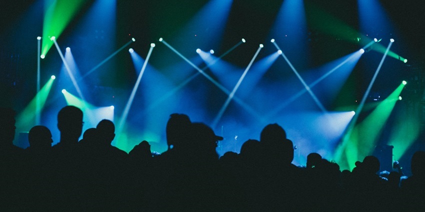 Silhouette of people in the nightclub surrounded by the vibrant green and blue lightning