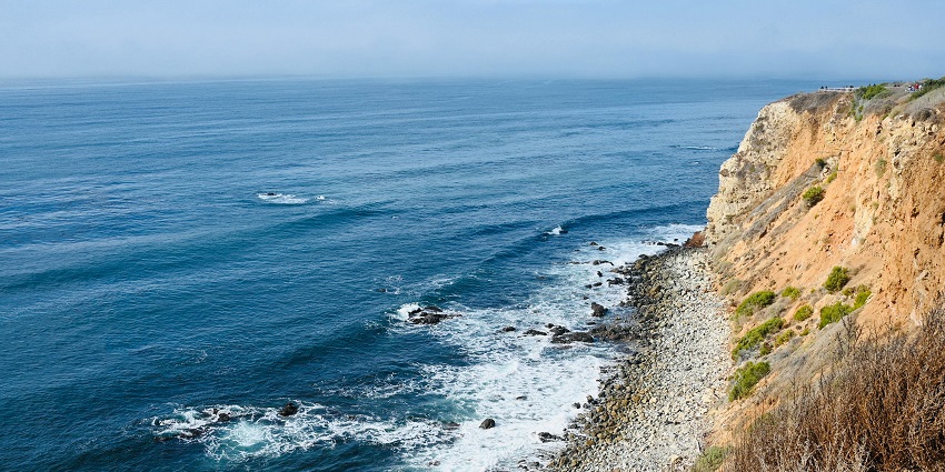 A transparent body of water is surrounding the beach, showcasing its pristine condition.