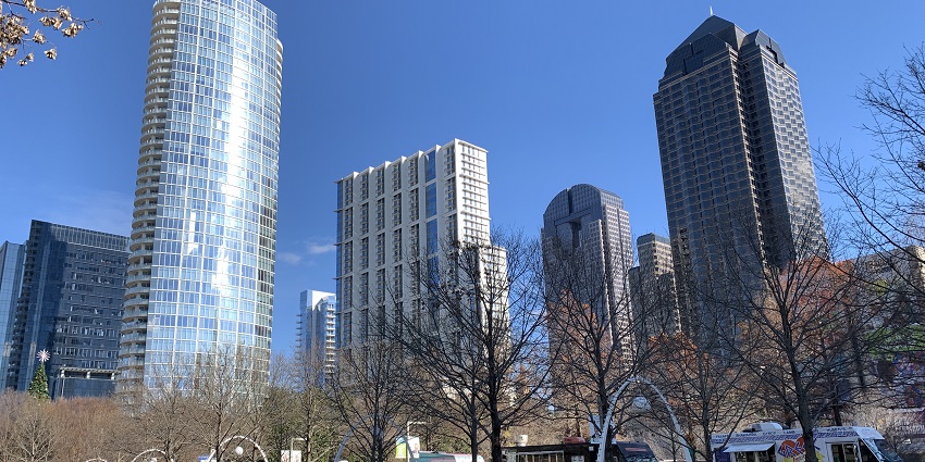 Green urban park with people enjoying food trucks, events, and recreational activities.