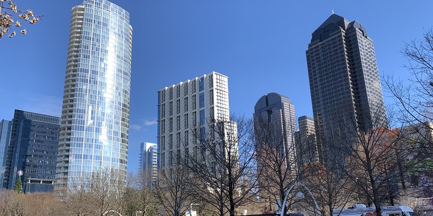 An image of Klyde Warren Park, surrounded by buildings, greens and food trucks.