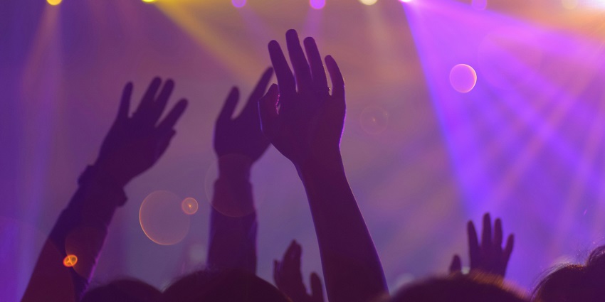 An image of people cheering and celebrating together in a lively nightclub atmosphere.