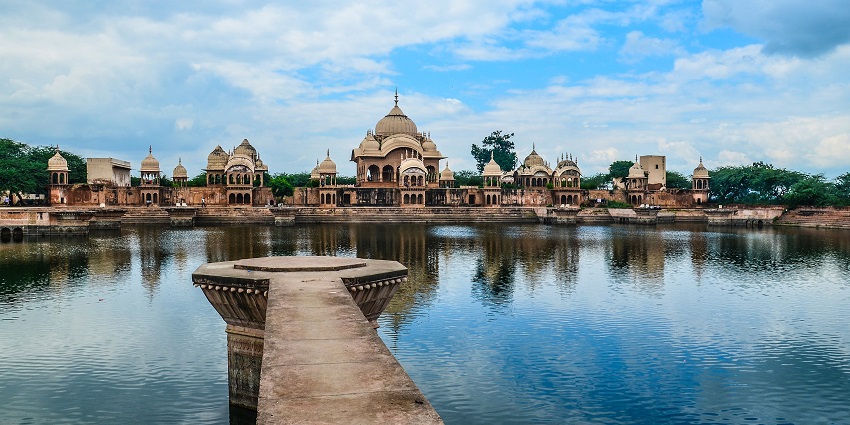 An image of Kusum Sarovar with dome structures that reflect off the water bodies.
