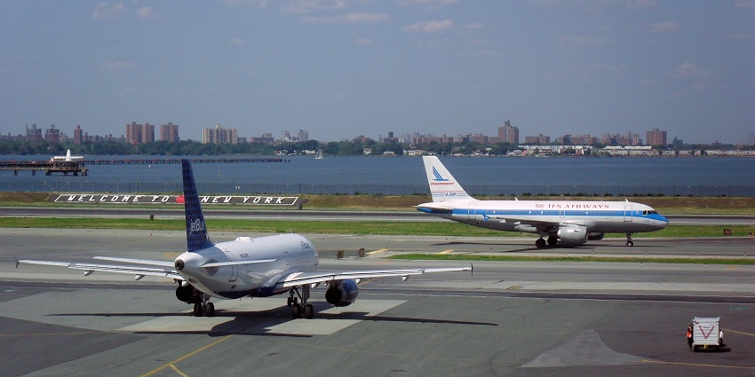 A vibrant view of LaGuardia Airport with planes and terminal in October 2023.