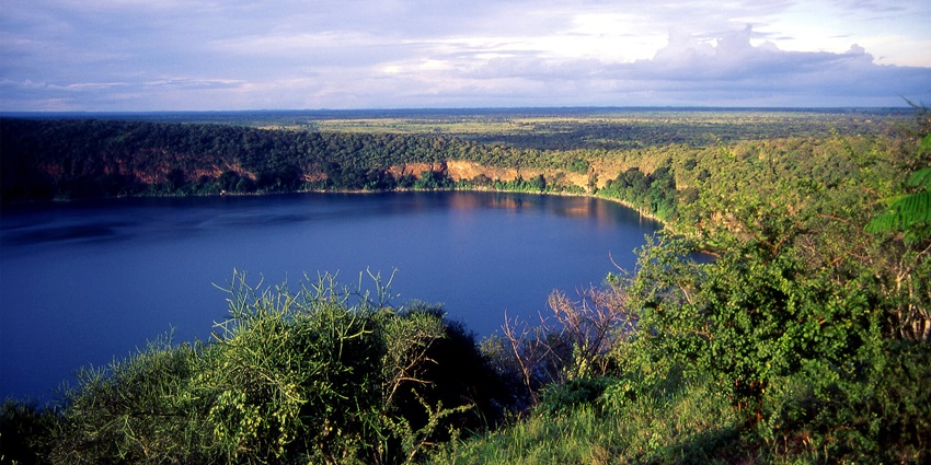Lake Chula with its blue calm water surrounded by a steep crater rim covered in greenery