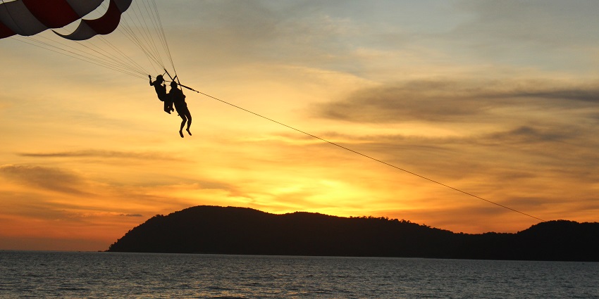 The Malaysia travel guide offers parasailing at Langkawi Island with scenic views.