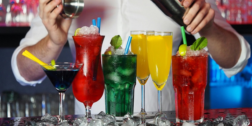 An image showing a man making drink and colourful glasses, resembling the Lebowski Bar