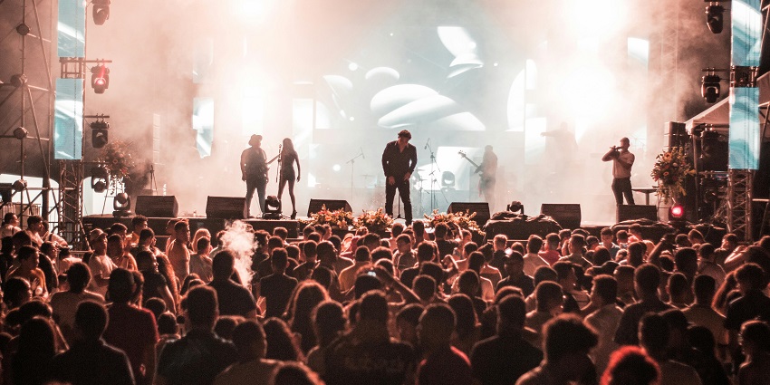 Dua Lipa performing live at a September music festival in the USA, showcasing vibrant energy.