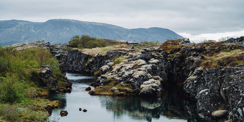 An image showing Flosagjá Canyon in Thingvellir National Park featuring dramatic rock formations.
