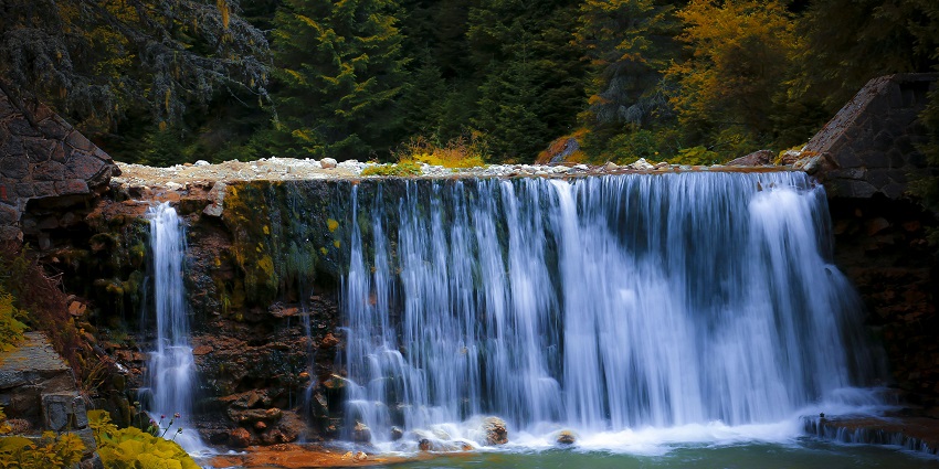An image of Wembley Waterfalls gently cascading over rocks into a calm, clear pool below.