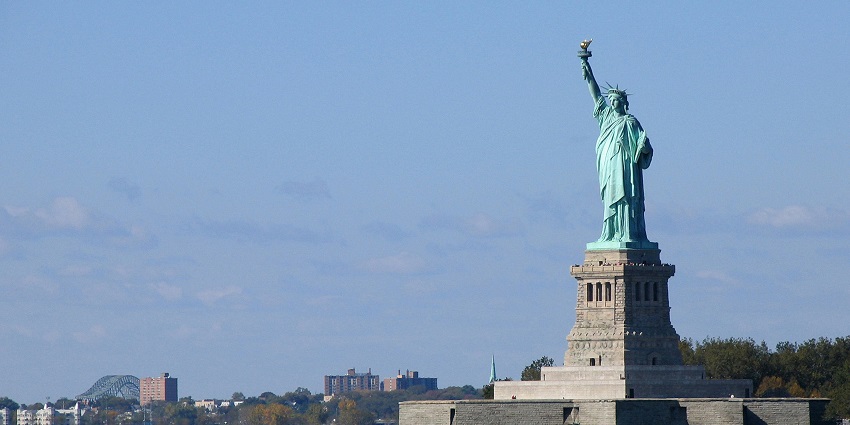 Picturesque view of statue of Liberty and a ferry - visitors enjoying the ferry ride