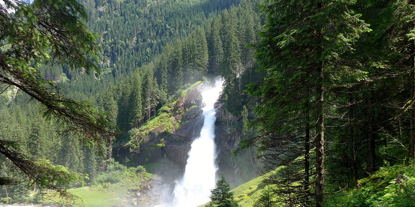 A scenic view of the main destination surrounded by lush green trees and mountains.