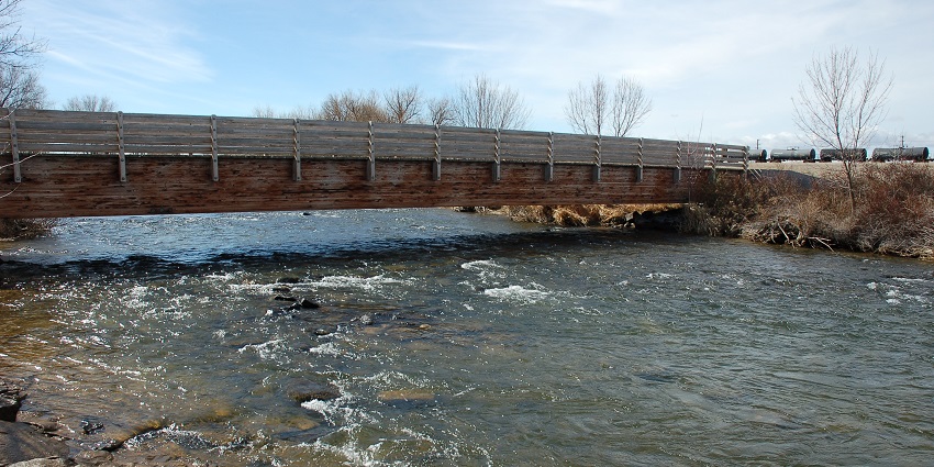 The view of the bridge leading towards the Kuna Caves and the Snake River flowing gracefully beneath it