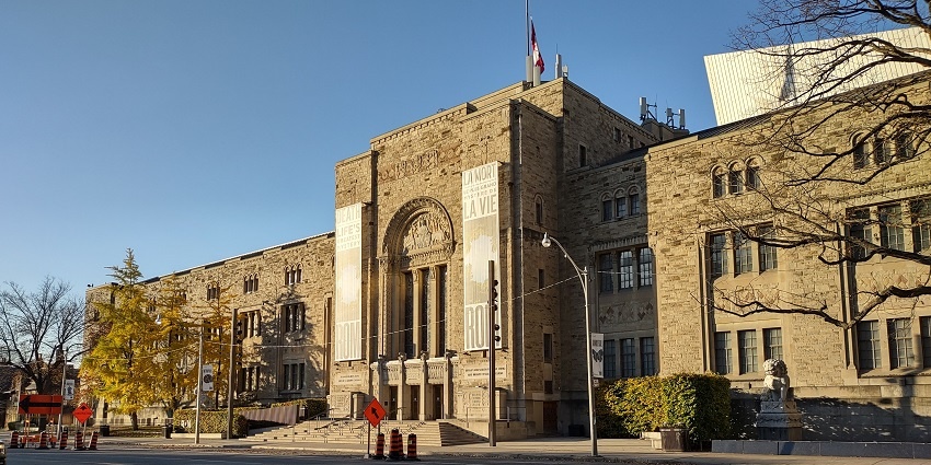 Outside view of Royal Ontario Museum featuring its stone brick structure and stairs leading to the entrance